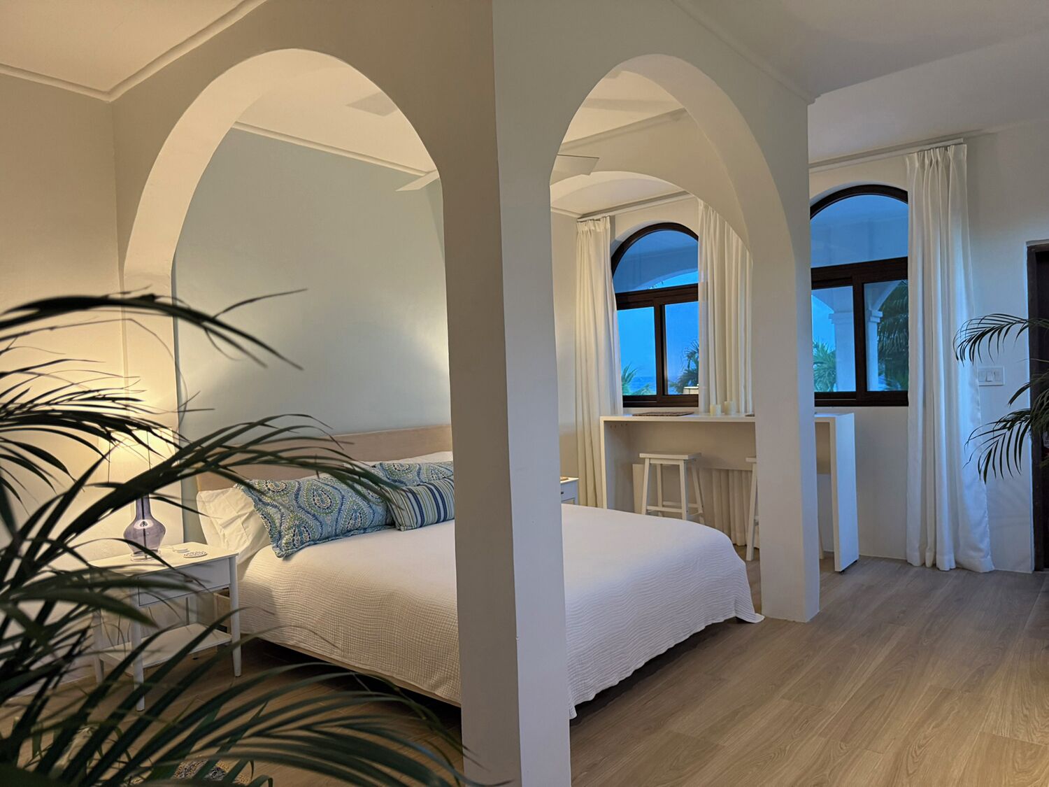 Une chambre à coucher avec un lit, un bureau et une fenêtre avec des rideaux.