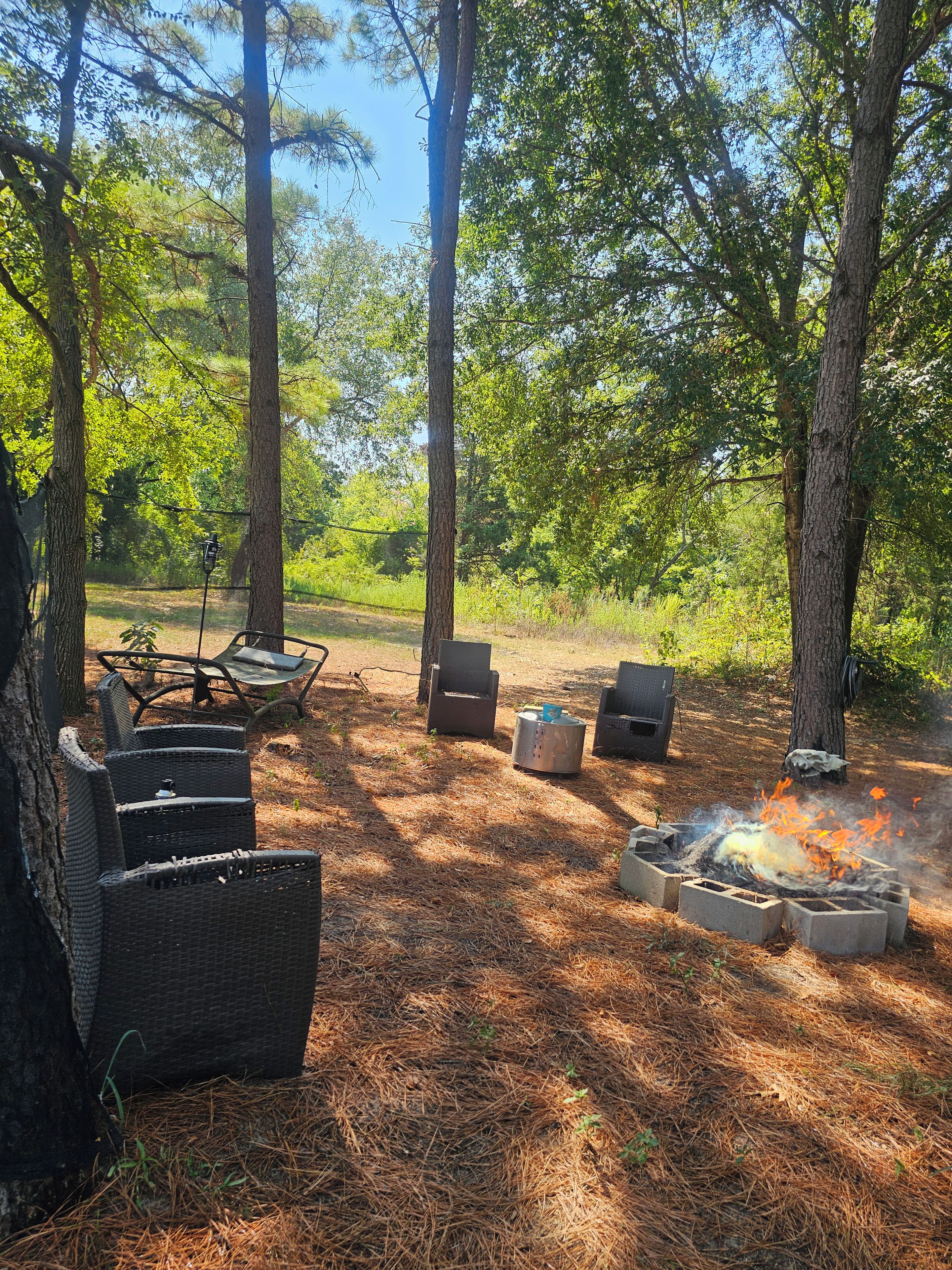 An outdoor seating area with wicker furniture and a fire pit.