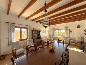 A dining area with a wooden table, chairs, and a chandelier. - Can Miquel, Traditional Villa with Private Pool (Son Proenç)