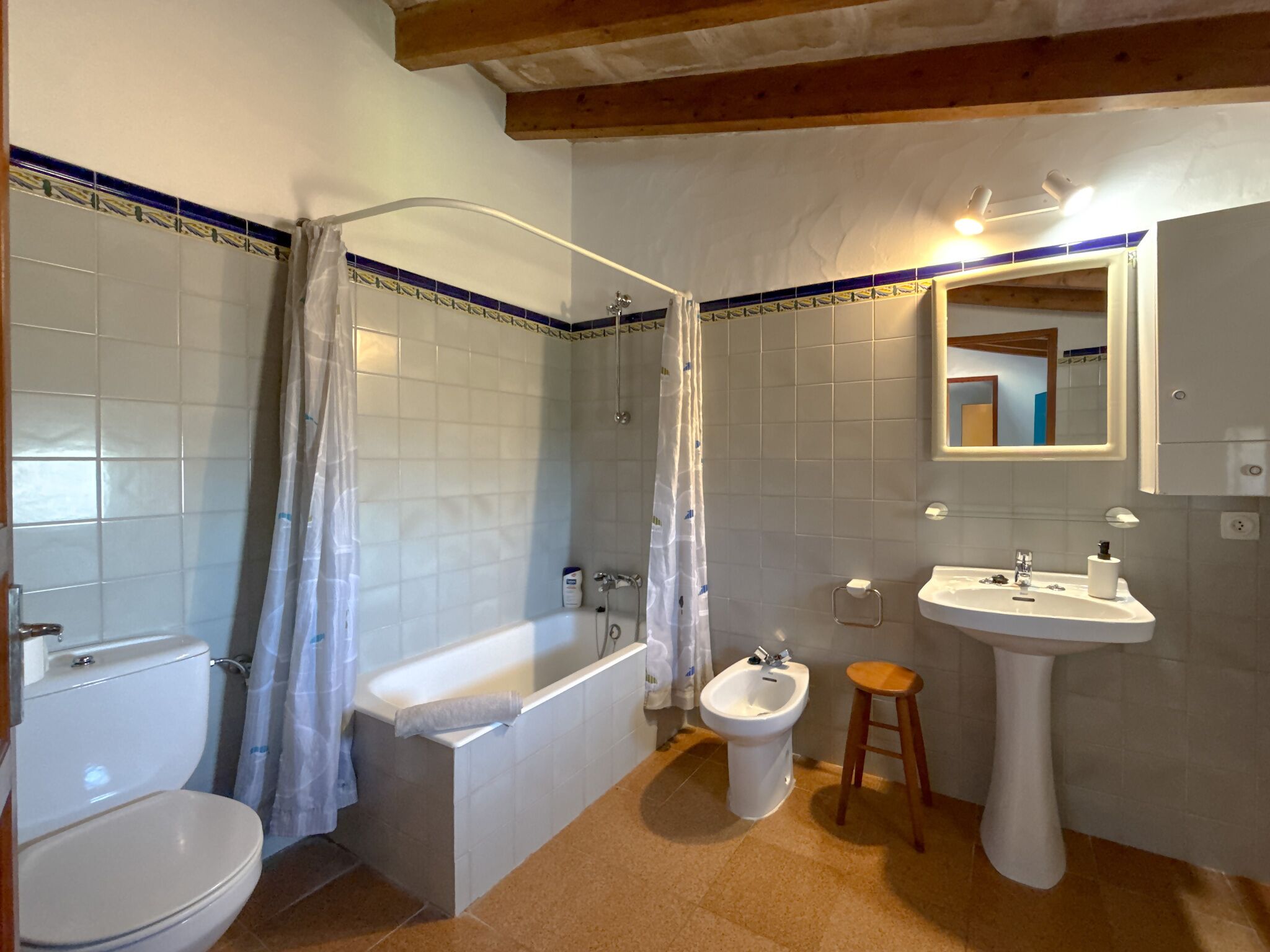 A bathroom with a bathtub, toilet, bidet, and sink.