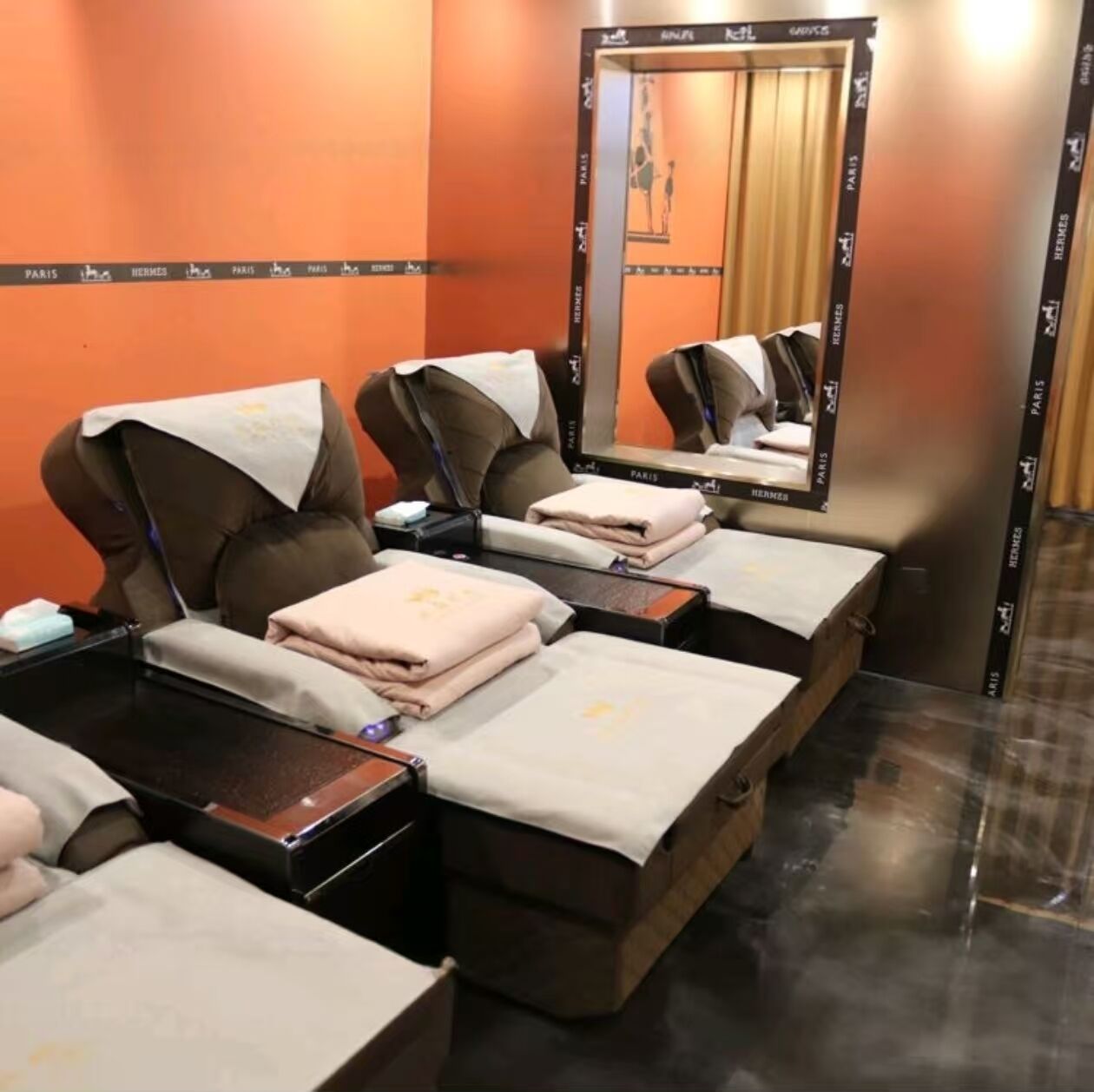 A room with multiple beds, each with a pillow and a folded towel.