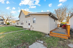 A single-story house with a front porch, a small yard, and a visible garage door.