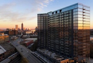 Ein modernes Hochhaus mit Glasfassade, umgeben von städtischen Straßen und weiteren Gebäuden.