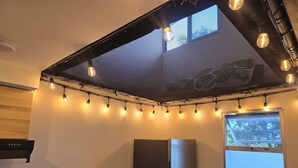 Eine Küche mit modernem Design, ausgestattet mit einem Edelstahlkühlschrank, einer Spüle mit Armatur und einer Arbeitsplatte mit verschiedenen Küchenutensilien.