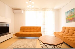 A modern living room with a sofa, a coffee table, and a TV. - Sanpietro Vacation Apartment 050 (Ishëm)