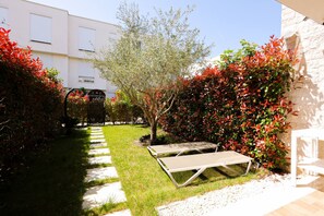 A garden with a pathway, a tree, and two lounge chairs. - Ground-floor Apartment Private Garden (Ishëm)