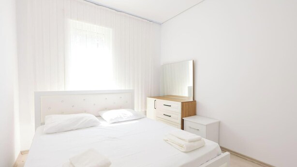 Ein Schlafzimmer mit einem Bett, einem Nachttisch und einem Spiegel.