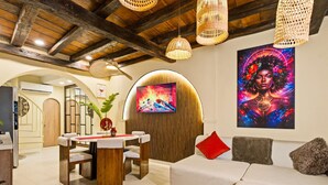 Un intérieur moderne comprenant un coin repas, un canapé et un grand tableau.