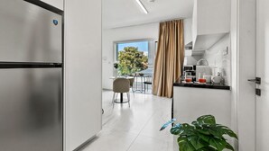 Una cocina moderna con horno empotrado, una zona de comedor con mesa y sillas, y vistas al exterior.