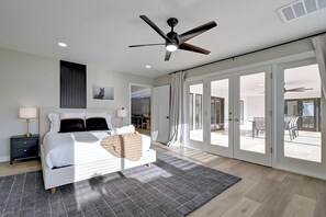 Ein modernes Schlafzimmer mit einem Bett, einem Nachttisch und einem Deckenventilator.