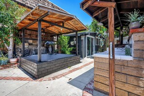 A spa area with a wooden canopy, a hot tub, and a brick wall. - Serene 2BR Valley Glen Oasis: Private Yard, & BBQ (Los Angeles)