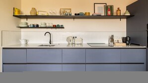 A modern kitchen with a white countertop, two sinks, a coffee machine, and a toaster. - Balham Modern - Stylish 1bed Flat With Balcony (Moffat)