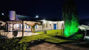 Un bâtiment doté d’un patio couvert, d’un grand arbre et d’une pelouse bien entretenue.
