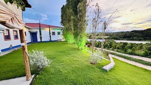 Une pelouse bien entretenue, un bâtiment avec un toit rouge et un ciel dégagé.