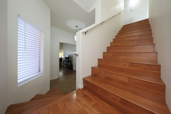 A wooden staircase with white walls and a door leading to a room with a desk and chair. - Spacious 4-bedroom house with office and loft in fabulous Tucson. (Tucson)