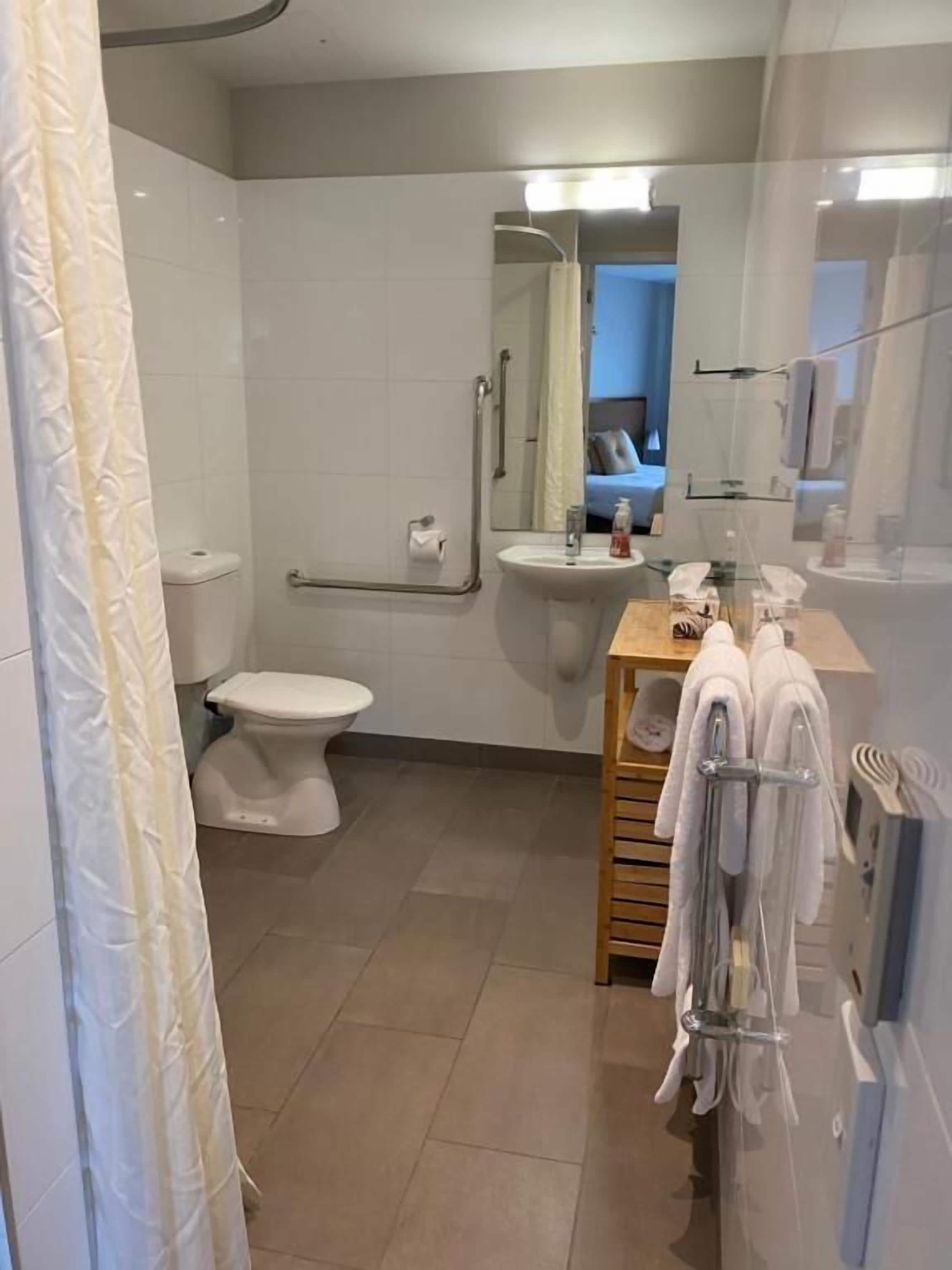 Ein Badezimmer mit Toilette, Waschbecken und Dusche.