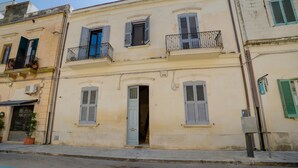 A multi-story building with balconies, a door, and a parking sign. - Archi Home - Apartment with Balcony in Central Lecce, Lecce, Italy (Lecce)