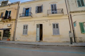 A multi-story building with balconies, a door, and a parking sign. - Archi Home - Apartment with Balcony in Central Lecce, Lecce, Italy (Lecce)