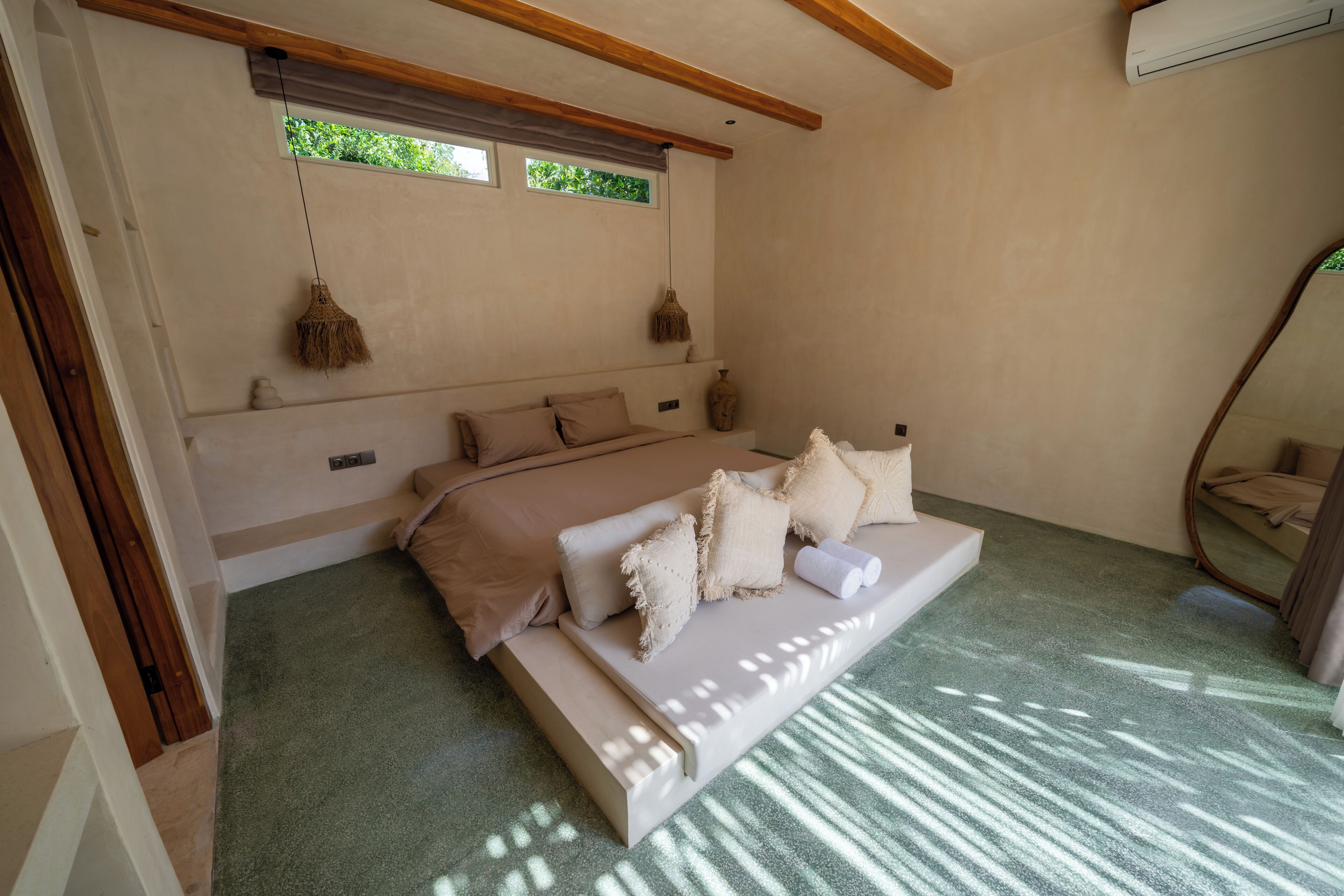 Une chambre à coucher avec un lit, une fenêtre, une lampe suspendue et un ventilateur de plafond.