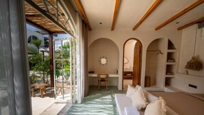Una habitación con sofá, escritorio y vistas al exterior.