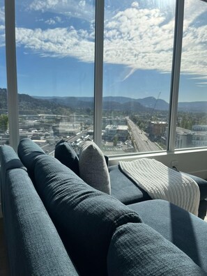 Aussicht aus einem Fenster mit Stadtansicht, darunter Gebäude und Berge.
