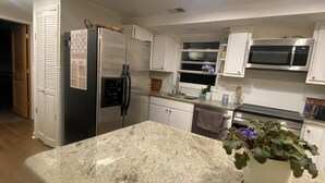 A modern kitchen with granite countertops, stainless steel appliances, and white cabinetry. - 1-bedroom townhome in Odenton with guest share bath. (Odenton)