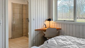 A bedroom with a bed, a desk with a chair, a shower, and a window with a view of trees. - Nice home in Oksbøl with WiFi (Oksbøl)