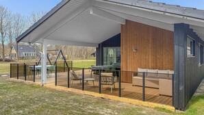 A modern house with a covered patio, outdoor furniture, and a view of the surrounding area. - Nice home in Oksbøl with WiFi (Oksbøl)