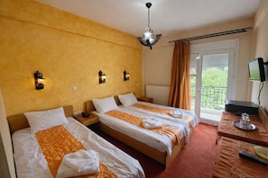 A hotel room with two beds, a TV, a window with curtains, and a balcony. - Ducata Hotel - Triple Room With Balcony & Views (Veroia)