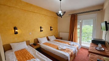 Habitación de hotel con dos camas, una lámpara en el techo, un televisor y una ventana con cortinas.