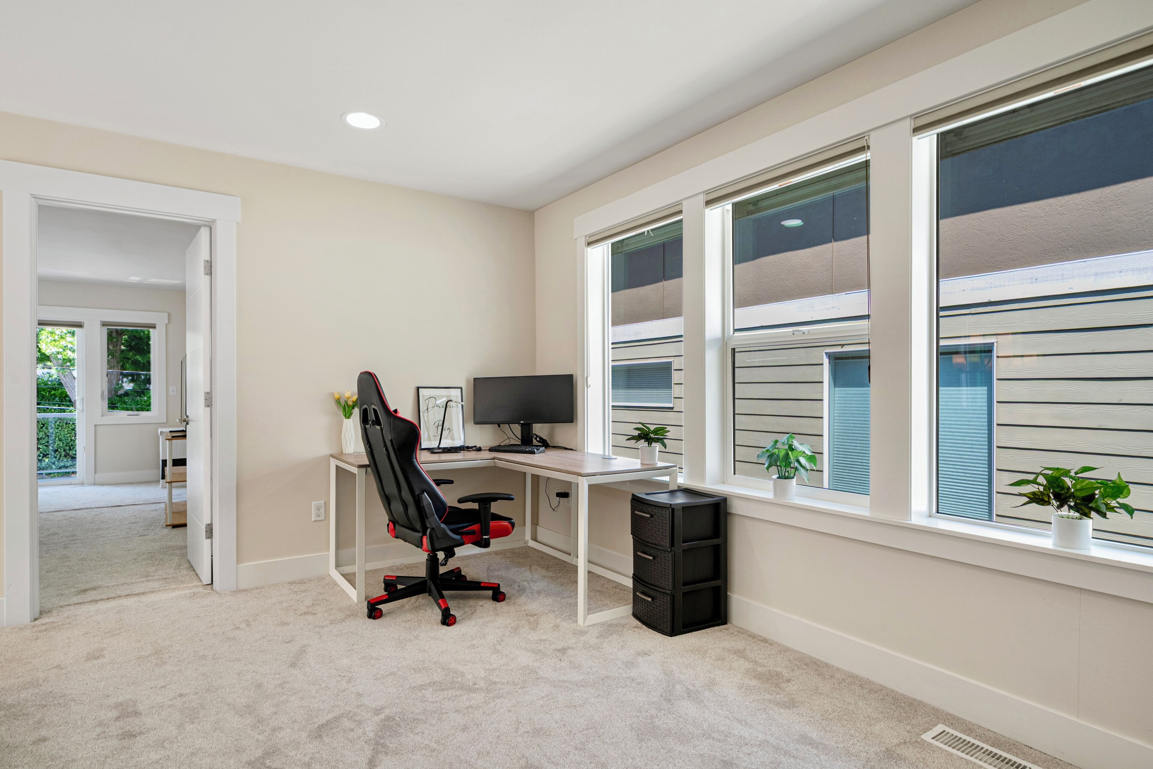 Un espace de bureau moderne comprenant un bureau, une chaise, un ordinateur et des plantes en pot.