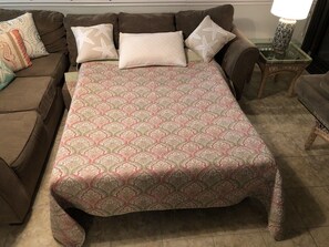 A bed with a patterned bedspread, a brown sofa with decorative pillows, and a small side table with a lamp. - Oceanfront Spacious, 4 Bedroom Condo, Best Amenities & Views, Sleeps 12-14 (Ocean City)