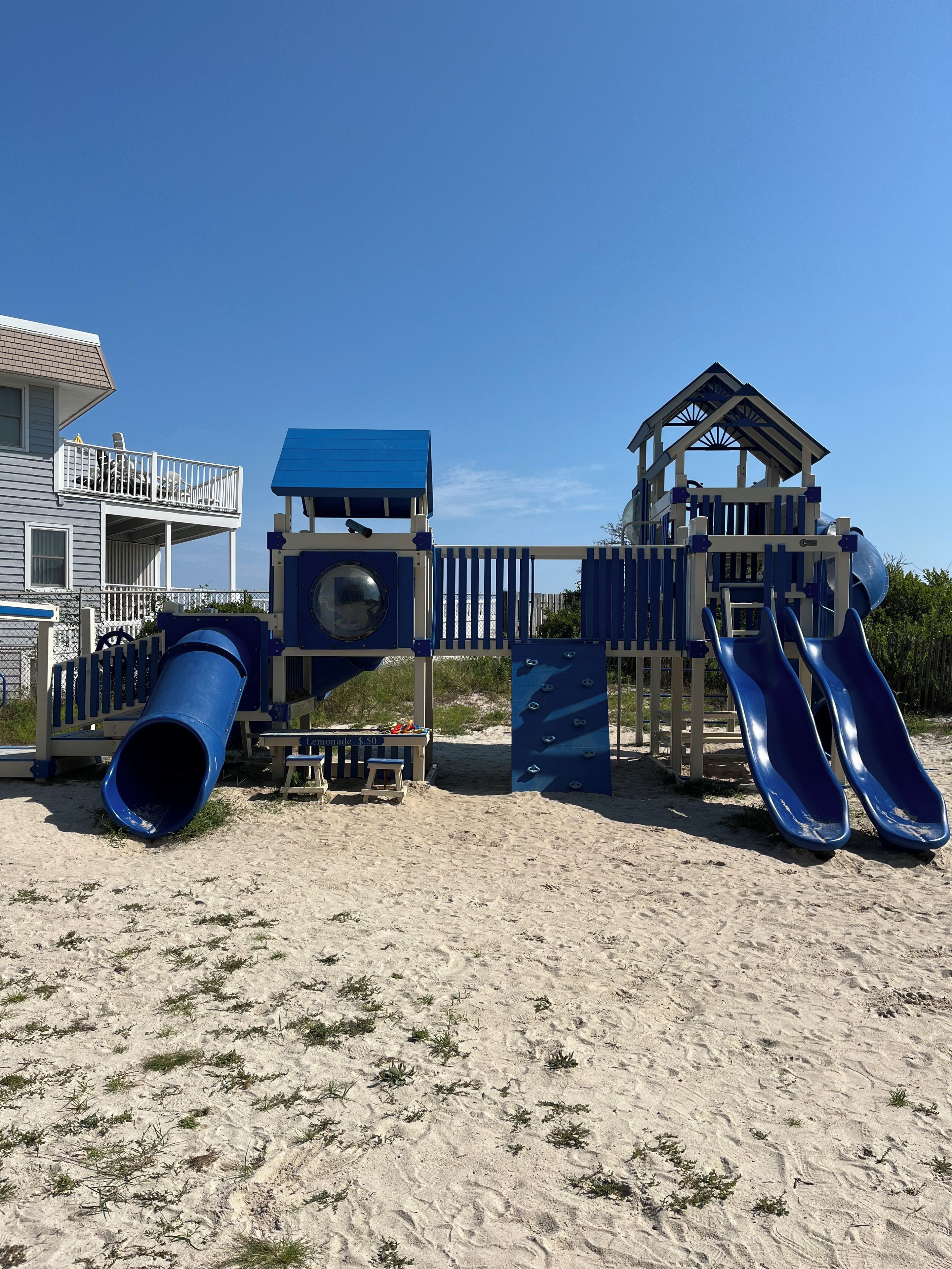 A beach playground with slides and a lemonade stand.