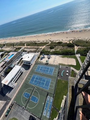 An aerial view of a beachside property with tennis courts, a pool, and a beach. - Oceanfront Spacious, 4 Bedroom Condo, Best Amenities & Views, Sleeps 12-14 (Ocean City)
