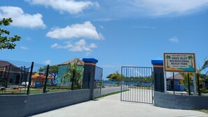 A gated entrance to Gros Islet Recreational Beach Park with a clear sky.