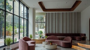 Un intérieur moderne avec de grandes fenêtres, un plafond incurvé et un espace salon comprenant des canapés et une table basse.