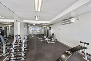 A gym with weight machines, dumbbells, and a bench. - LaneStay - 2BR in Southbank w Large Living and Gym (Southbank)