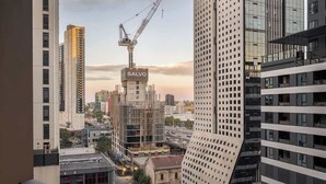 A high-rise building with a construction crane, a sign reading 'SALVO,' and surrounding modern architecture. - LaneStay - 2BR in Southbank w Large Living and Gym (Southbank)
