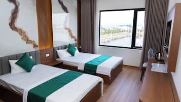 A hotel room with two beds, a large window, and a view of a body of water.