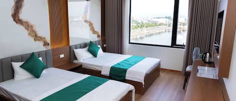 Habitación de hotel con dos camas, un ventanal grande y vista a un cuerpo de agua.