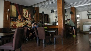 A restaurant with wooden walls, a mural, and patrons dining. - Ducata Hotel - Single Room With Balcony Views (Veroia)