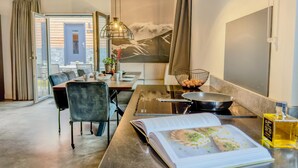 Una cucina moderna con zona pranzo, un libro e una bottiglia sul bancone.