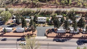 Un camping con vehículos recreativos, un edificio central y una carretera con automóviles.