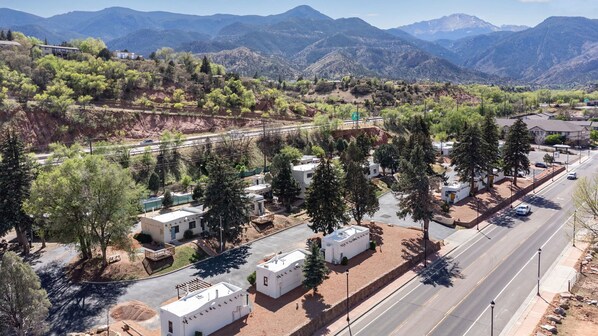 Un área residencial con vehículos recreativos, una carretera y montañas al fondo.