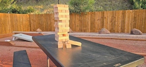 Eine hölzerne Konstruktion, ähnlich einem Jenga-Turm, auf einem schwarzen Tisch im Freien.