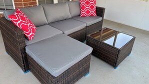 A sectional sofa with grey cushions and red patterned pillows, a glass-top coffee table, and a wicker frame. - Favor Home- Serene Spacious 3BR Near Augusta National, King Bed, Sleeps 8 (Martinez)