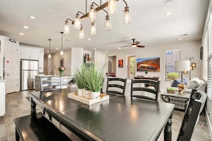 A modern kitchen with a large island, stainless steel appliances, and a dining area with a long table and chairs. - Town Center 2309, Private Hot Tub, Air Hockey Table, Community Amenities! (Washington)