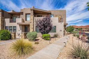 A modern two-story house with a stone facade, multiple windows, and a well-maintained garden with various plants and a pathway. - Town Center 2309, Private Hot Tub, Air Hockey Table, Community Amenities! (Washington)