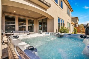 A spa area with hot tubs, a seating area, and a building with large windows. - Paseos 1366, Ping Pong Table, Basketball Arcade, Private Hot Tub, Community Amenities! (Washington)