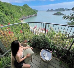 A balcony with a view of a coastal landscape, including a beach and distant islands. - Forest Sky Villa - Flamingo Cat Ba (Hai Phong)